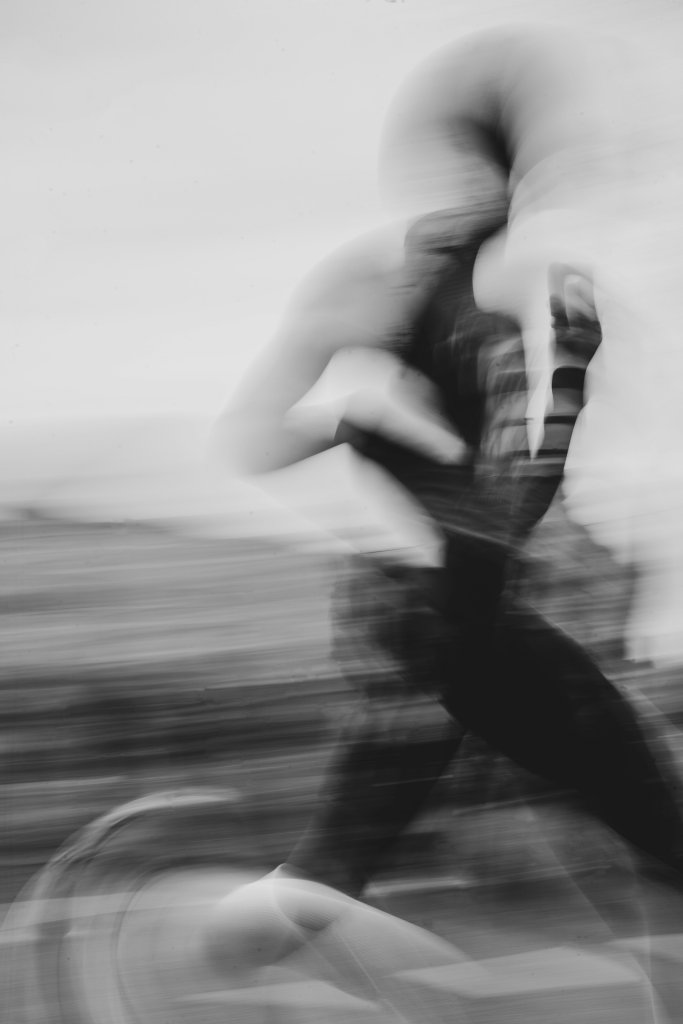 Black and white long-exposure photo of a runner in motion